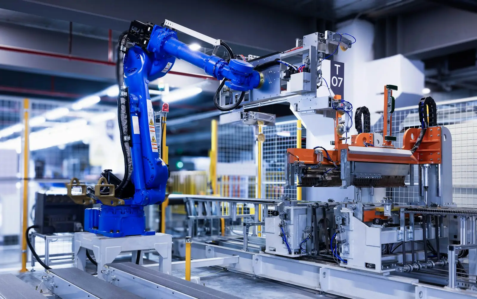 Blue industrial robot arm working on an automated factory production line