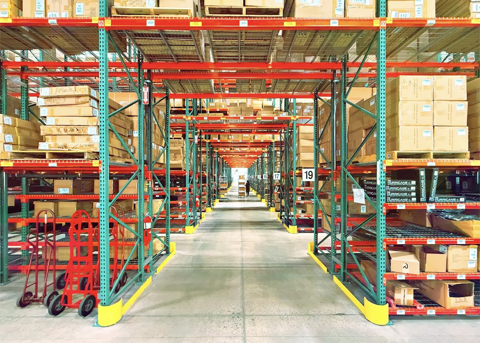 Long warehouse aisle lined with tall racks of stored goods